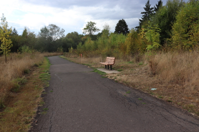 Beginning of wide, paved, Fanno Creek Trail with bench